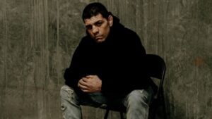 Nick Diaz sitting on a chair in a black hoodie
