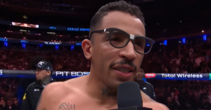 Carlos Prates wearing glasses during an in-cage post-fight interview at a UFC event