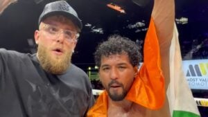 Jake Paul stands beside Neeraj Goyat, who raises his arm while draped in the Indian flag in the ring at a Most Valuable Promotions event