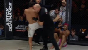 Referee holds back Khusein Askhabov as Reinaldo Ekson sits against the cage during chaos at Airtox Dominance FC 8 in Copenhagen